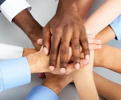 A group of people with their hands together.