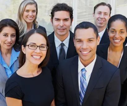 A group of people in business attire smiling for the camera.