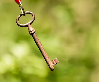 A key hanging from a red string with green background.