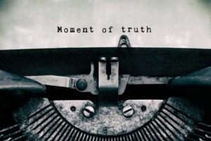 A typewriter with the words " moment of truth " written on it.